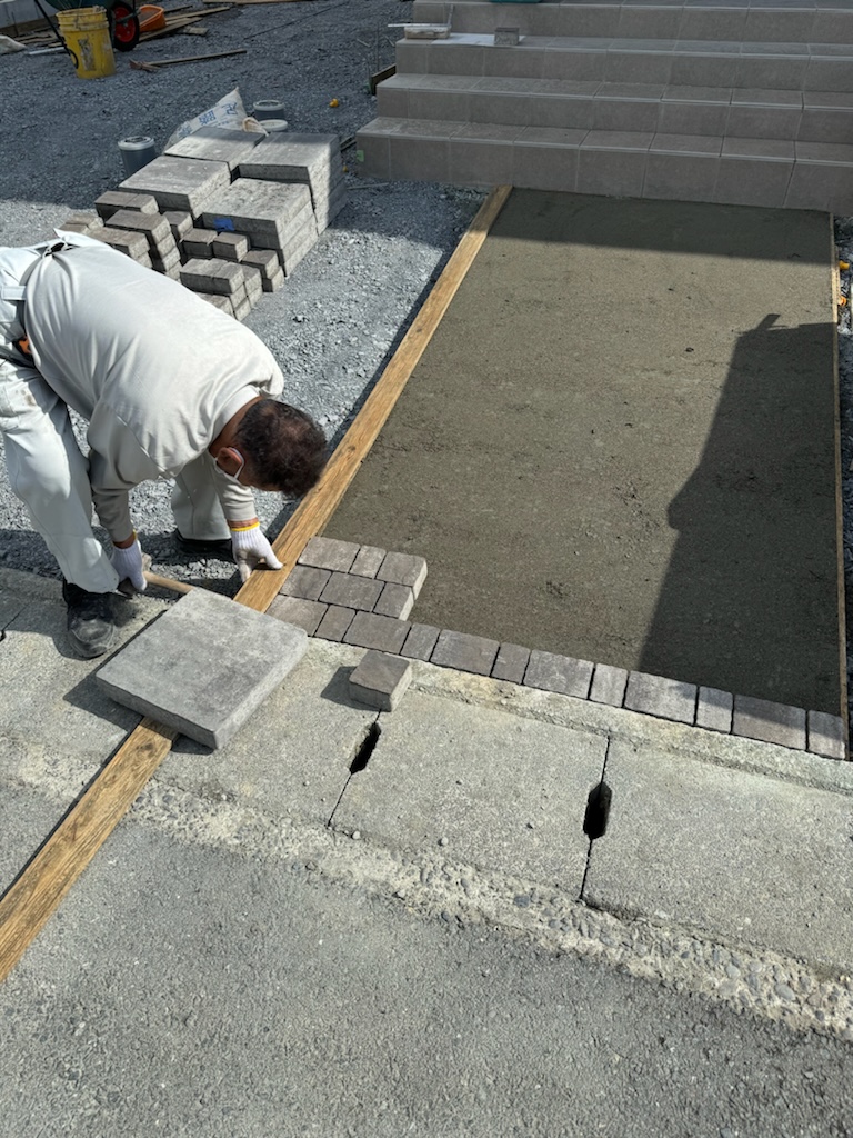 袋井市で建築中の工務店のエコーアートが行っている外構工事の石敷き施工の敷き始めている施工写真
