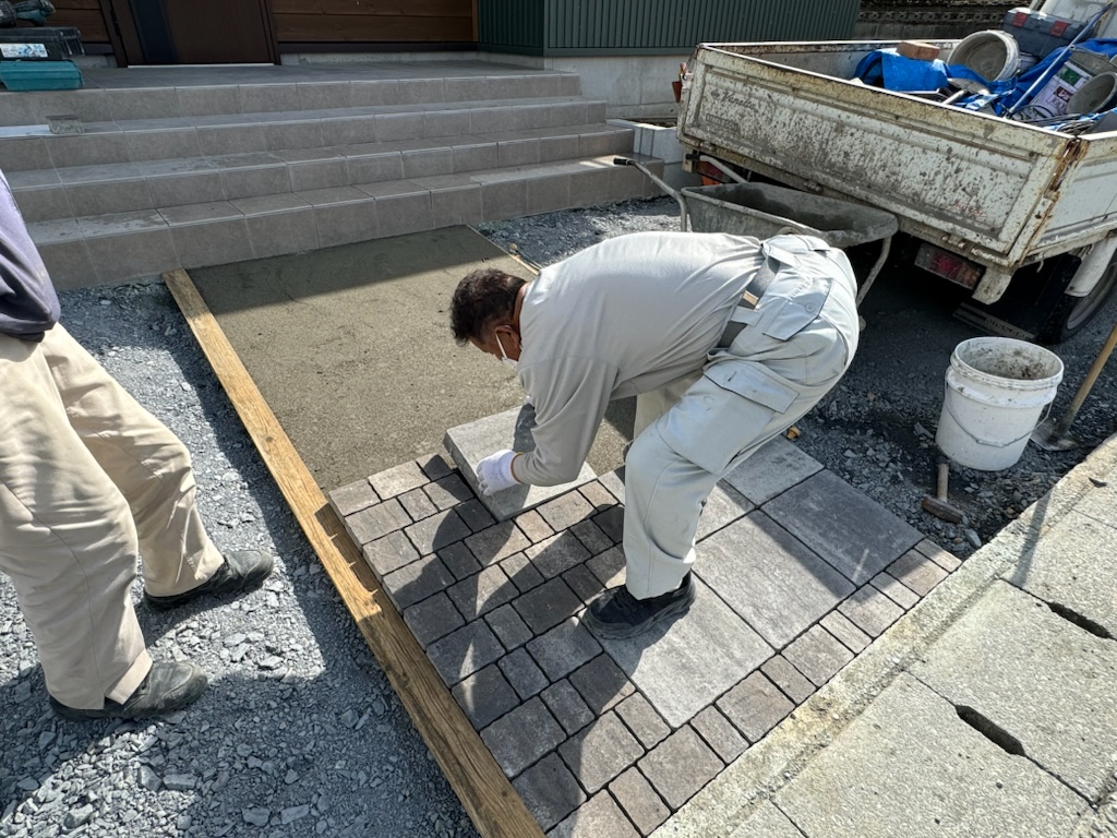 袋井市で建築中の工務店のエコーアートが行っている外構工事の石敷き施工をしているところの写真