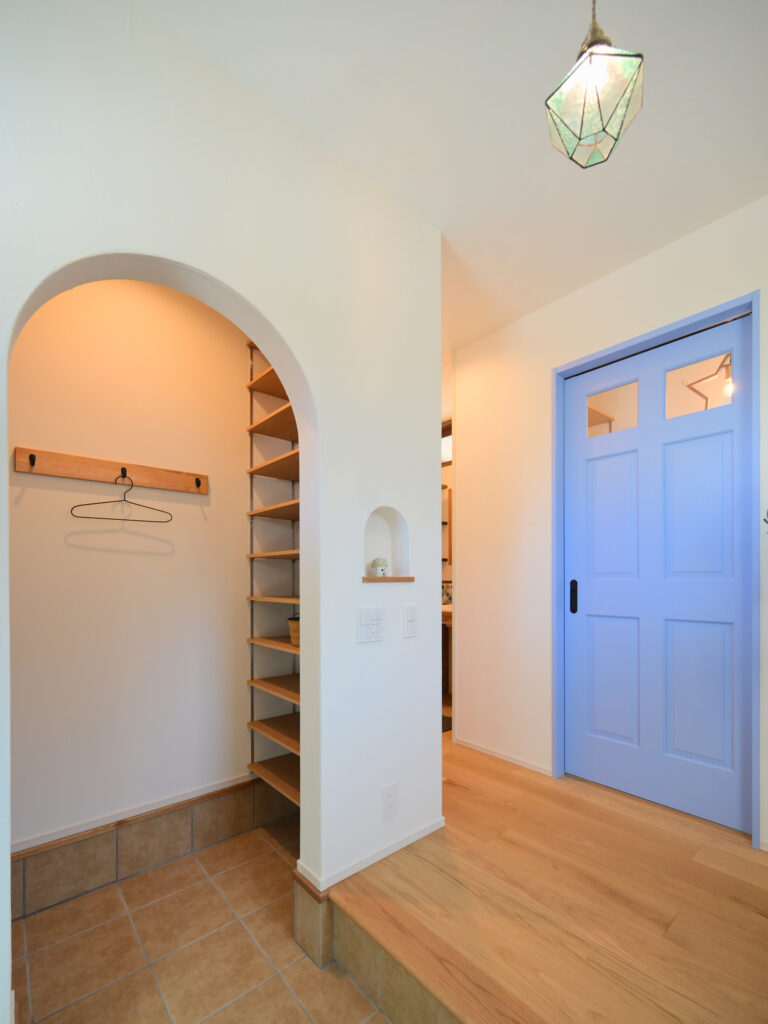 エコーアートが建てた青と質感にこだわったドーマーのあるかわいい家の玄関ホール斜め写真