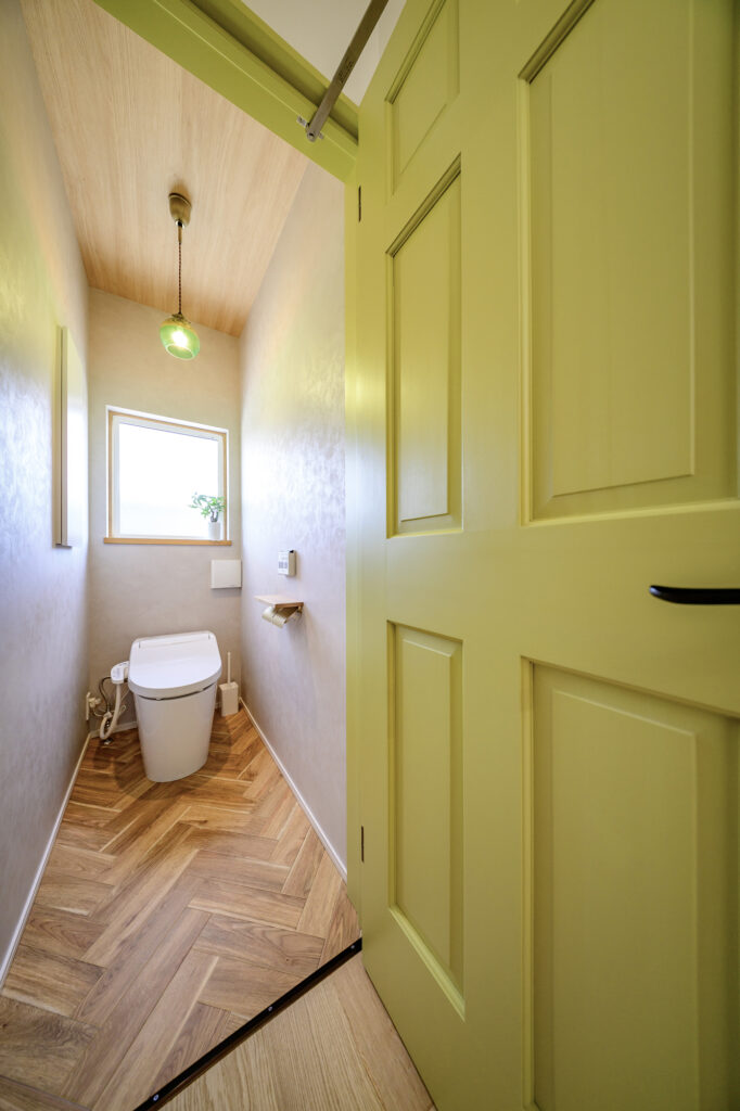 くすみグリーンが落ち着く大人かわいいカフェスタイルの家のトイレ正面写真
